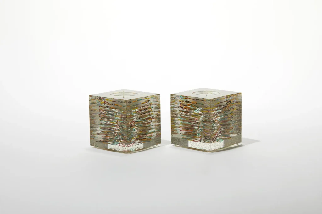 A pair of transparent glass cube candle holders with internal golden-brown textured patterns.