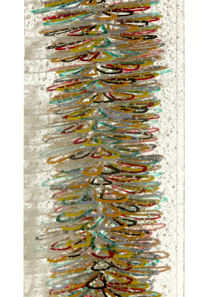 An extreme close-up of the sculpture's side, highlighting the vibrant colours and details of the individual hand-bent glass threads.