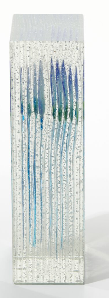 A side view close up of the clear glass block, highlighting the depth and detail of the fused jellyfish.