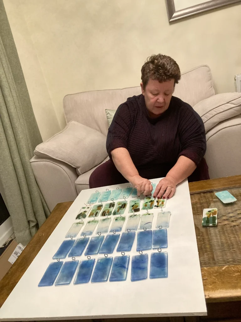 Rising Tire's artwork piece on a table with Julie working.