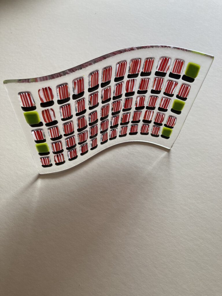 The finished "Sunderland 60 football wave" freestanding glass sculpture, showing the fused red and white shirts.